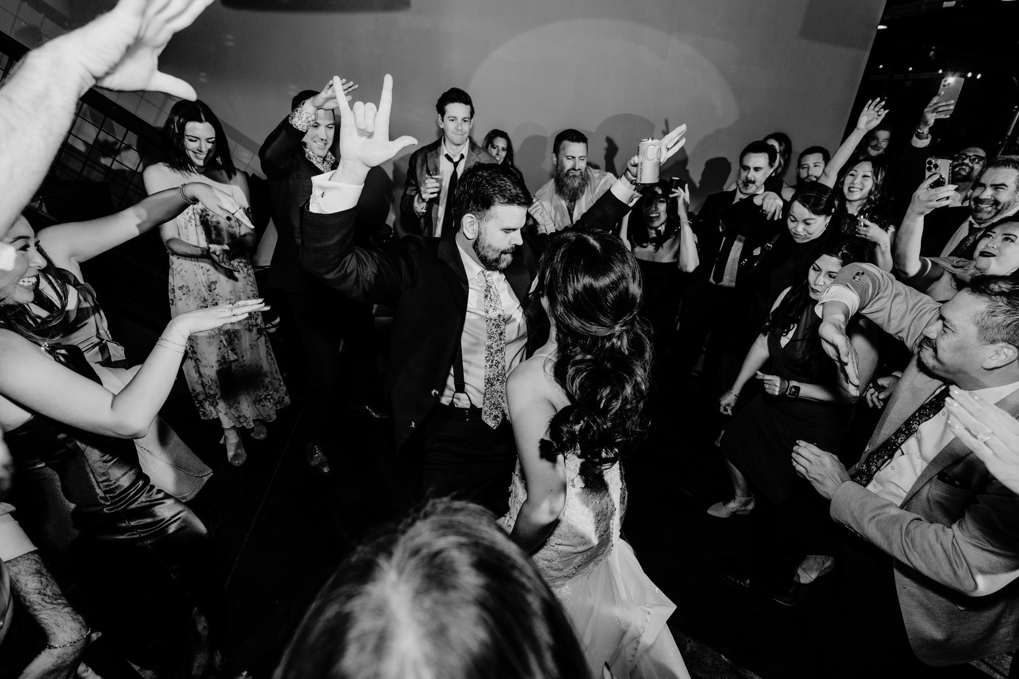 The bride and her friends in heart-shaped sunglasses, celebrating on the dance floor under string lights